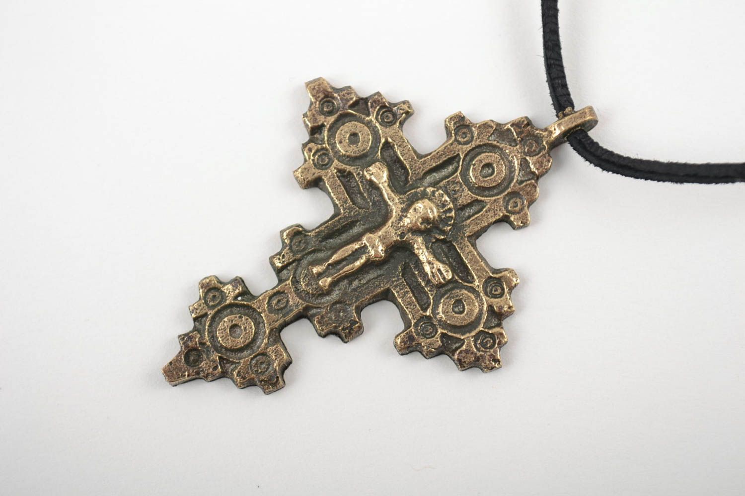 Bronze cross on a shoelace