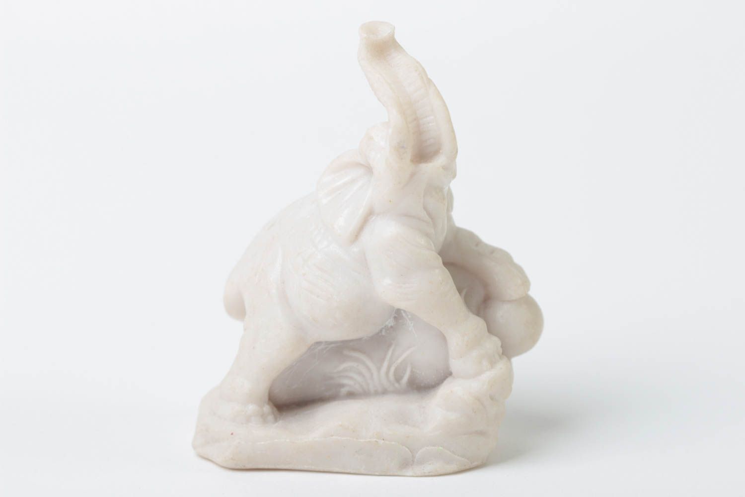A small elephant figure with a raised polymer resin trunk.