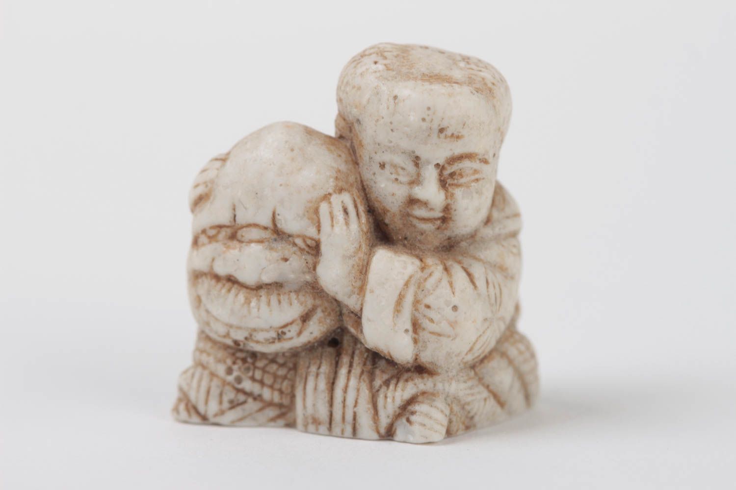 A small statuette in the form of an actor with a mask .