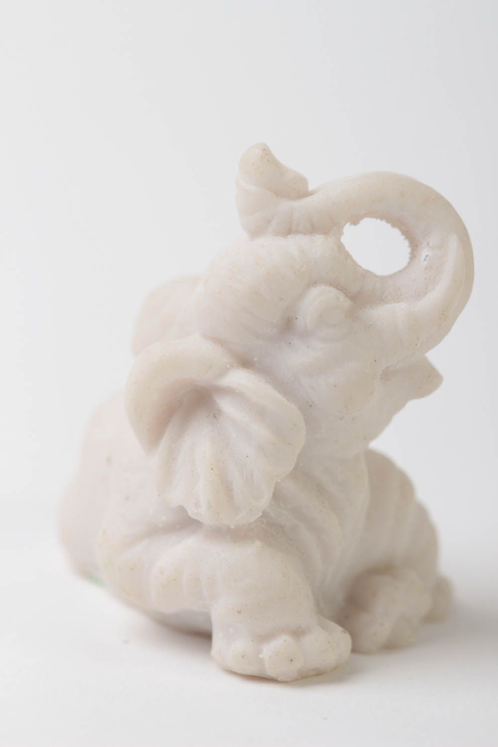 Elephant figurine with elevated trunk made of polymer resin.